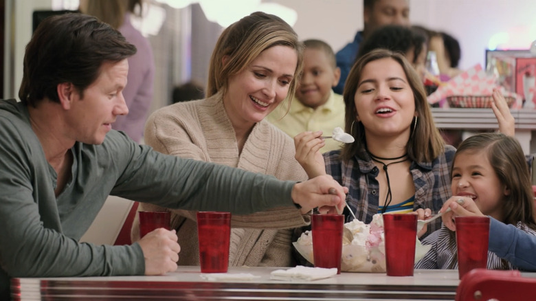 Mark Wahlberg as Peter Wagner and Rose Byrne as Elinore Wagner sit at a table with their kids in Instant Family