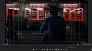 Screenshot of a man standing in front of a video store that says 'Media Giant' on the side of the building, with a video editing timeline below it.