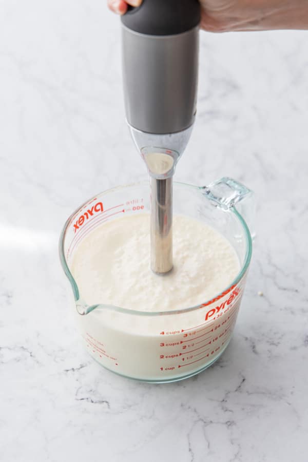 Blending the final ice cream base one more time with an immersion blender.