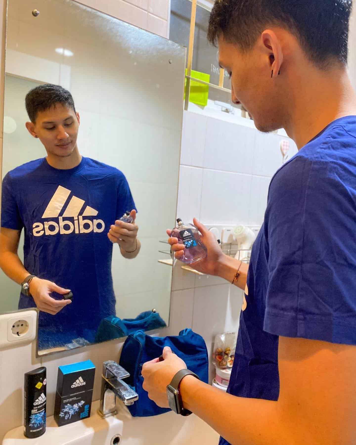 man holding a bottle of adidas ice dive cologne