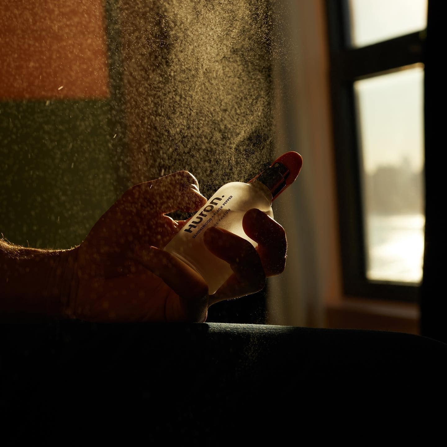 man spraying the huron eau de parfum cologne