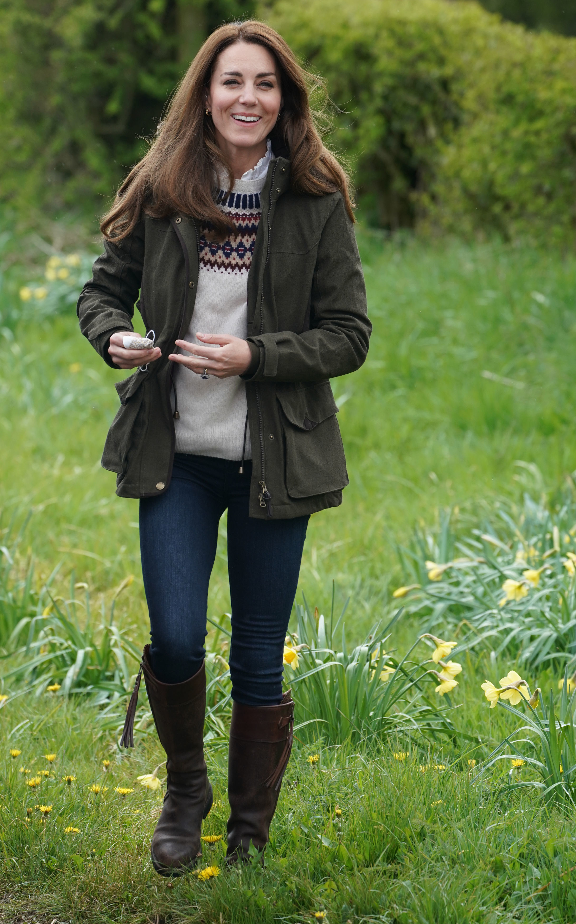 Kate Middleton wears skinny jeans, knee-high boots, and a green parka jacket