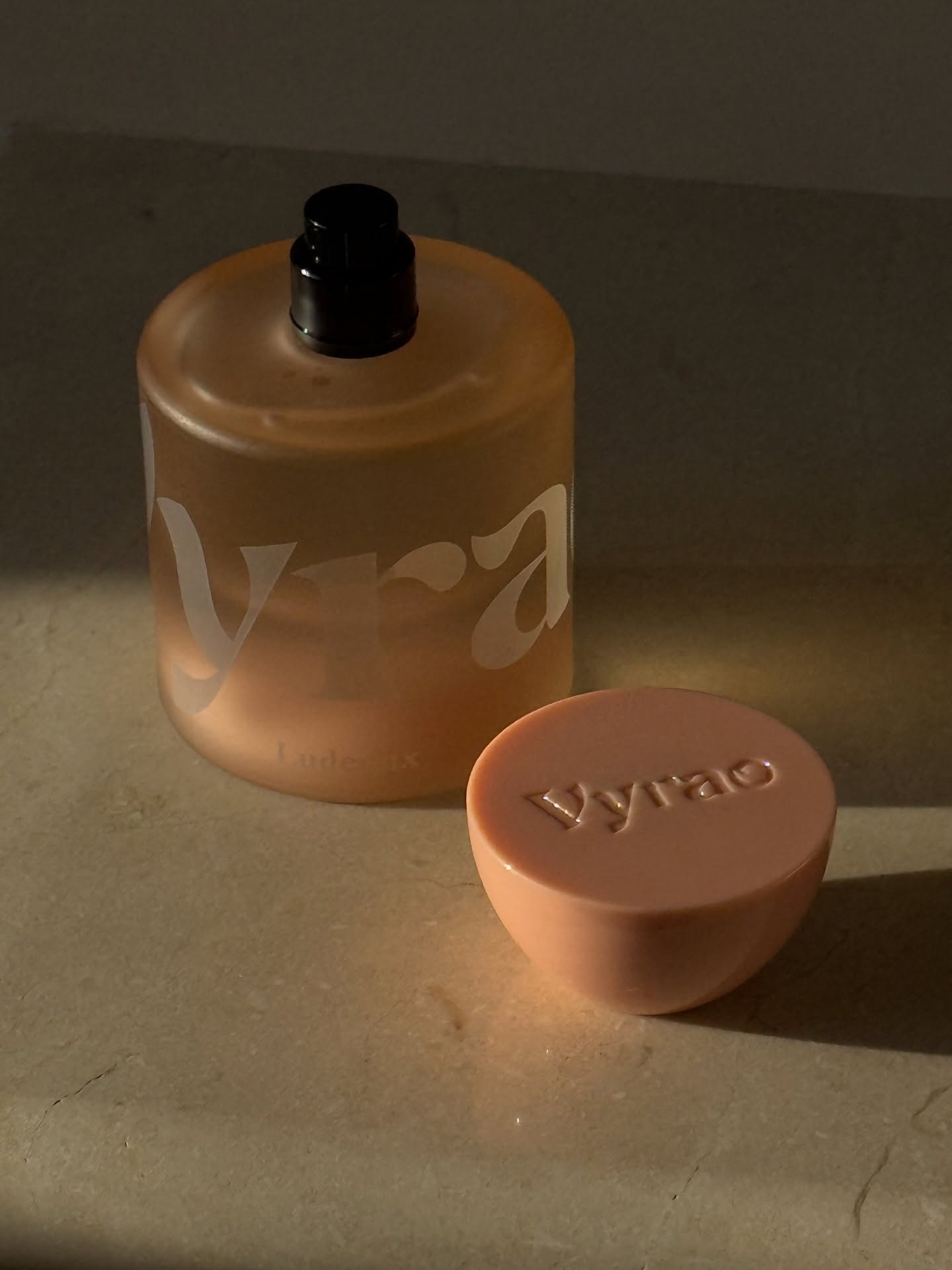 A bottle of Vyrao Ludeaux perfume sitting on a marble surface